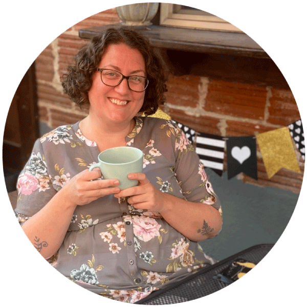 A smiling woman holding a cup of coffee