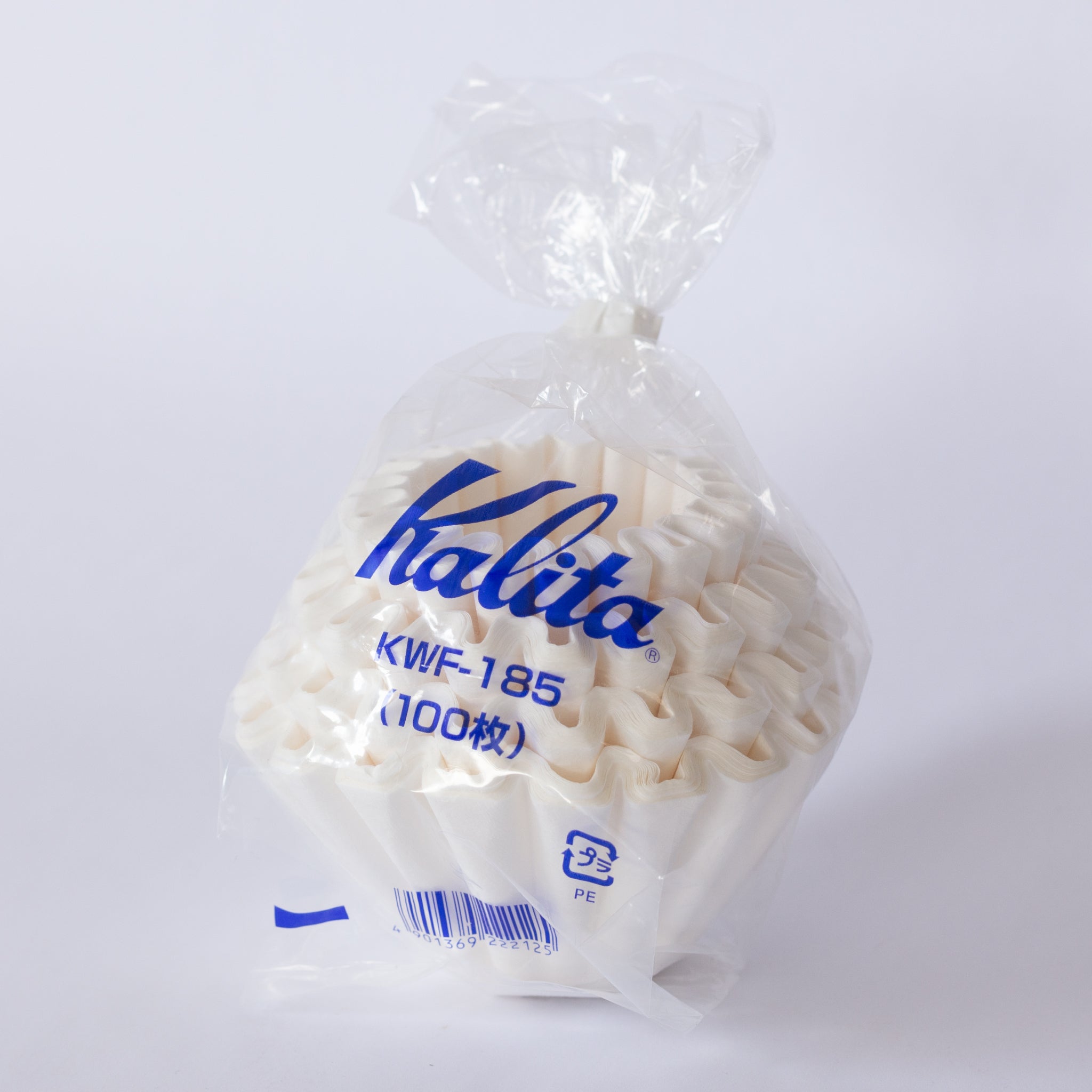 A stack of paper coffee filters wrapped in plastic packaging.