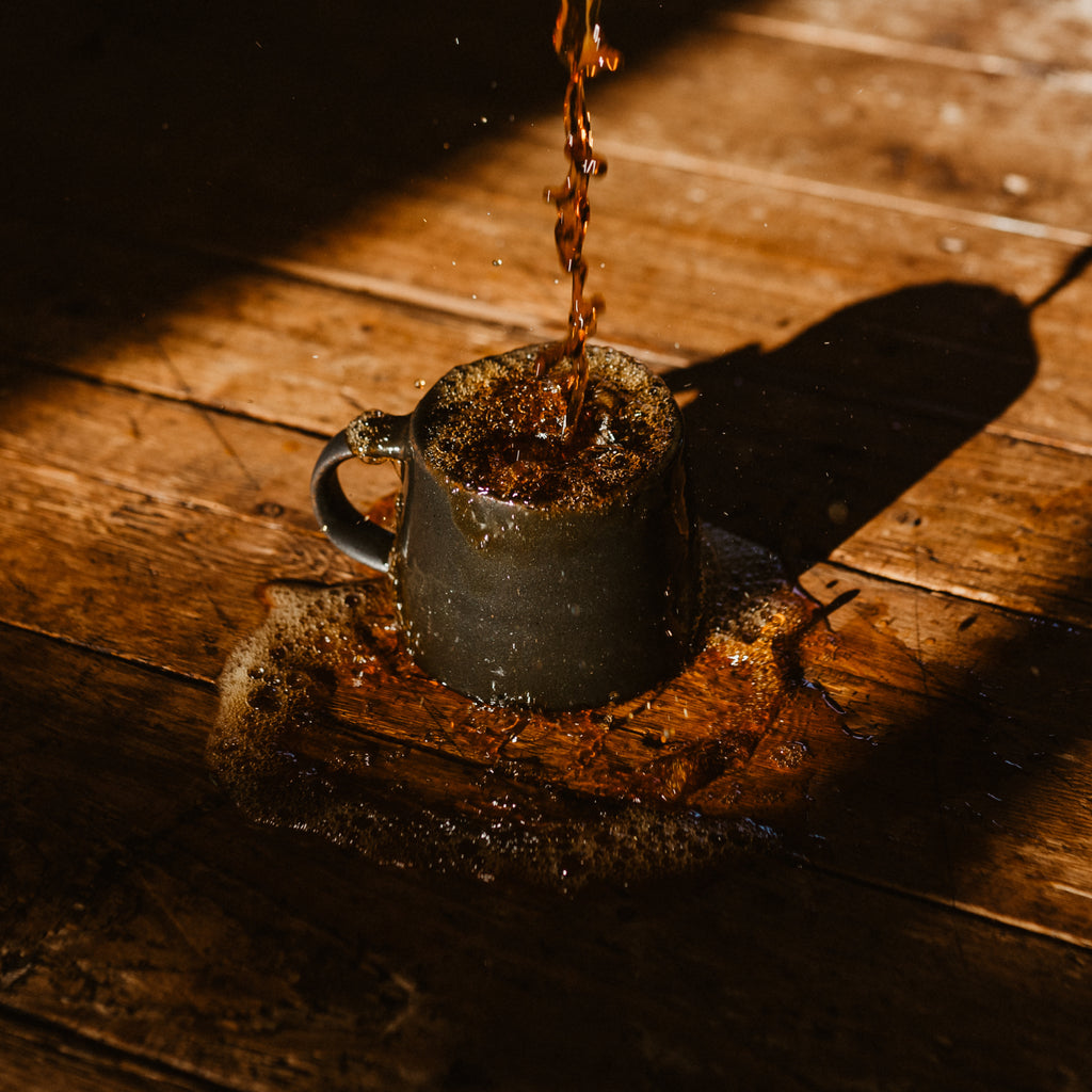 Coffee being poured into a mug and splashing