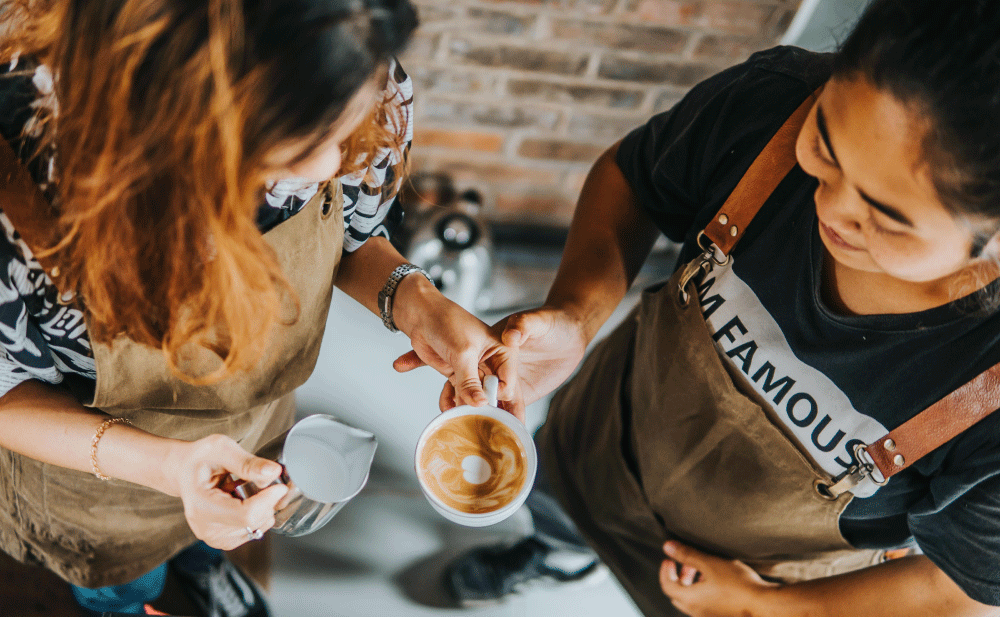 Two women making a latte coffee